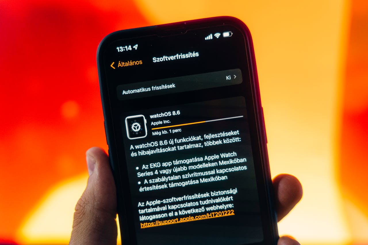 about-01 Hand holding a smartphone displaying WatchOS 8.6 update notification against warm gradient background.