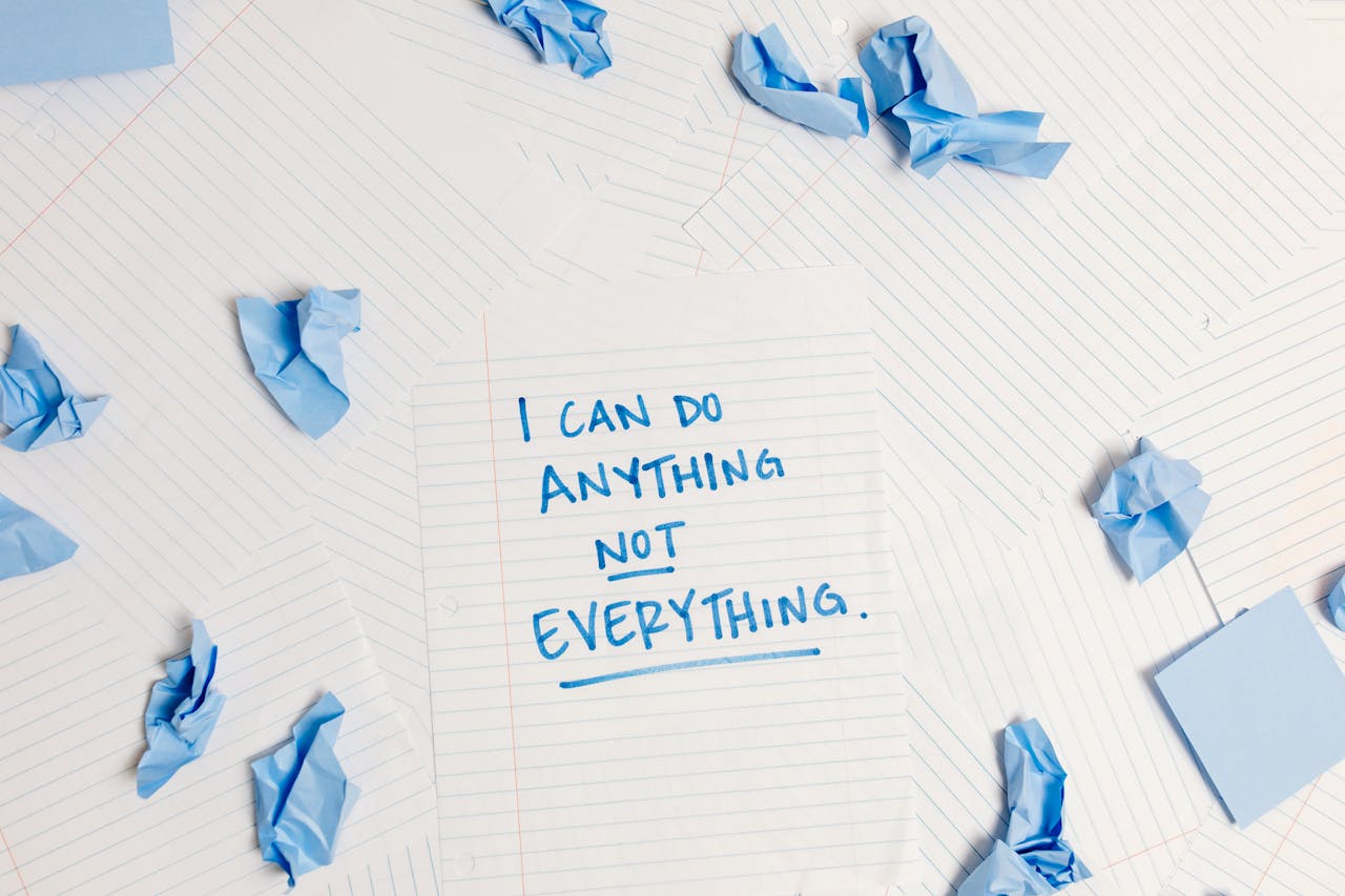 Inspirational message on a notepad surrounded by crumpled paper pieces.